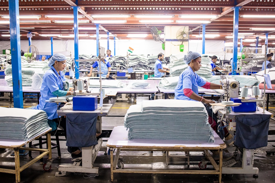 workers-sew-textiles-in-a-large-factory-setting-dh1edciq6lg